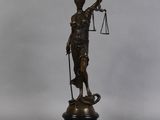 bronze statue of a lady holding a balance scale and a sword