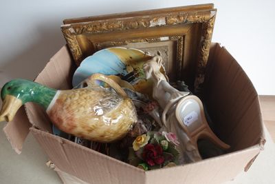 une boîte en carton contenant une image, un canard, un cadre photo et d'autres objets