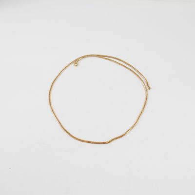 un bracelet en or avec une fine chaîne sur fond blanc