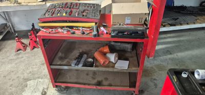 un établi rouge avec des outils dessus, dans un garage