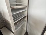 an open refrigerator in the corner of a kitchen