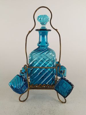 une bouteille en verre bleue posée sur un support en métal