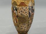 a gold vase with a picture of a woman on it