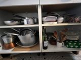 many pots and pans on the shelves in the kitchen