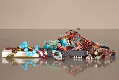 un tas de bijoux posé sur une table à côté d'un téléphone portable