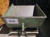 a green dumpster that is sitting on the ground