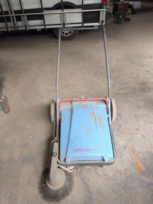 Quelqu'un est en train de nettoyer le sol avec un balai dans un garage