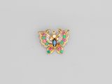 une broche en forme de papillon en or, ornée de pierres multicolores