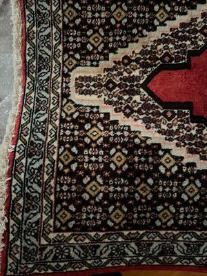 un tapis orné d'une croix rouge posé sur un parquet