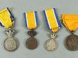 three medals and a medal on a gray surface