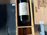 une bouteille de vin dans un coffret en bois sur une table