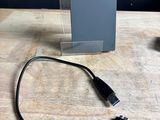un petit appareil branché à un chargeur posé sur une table
