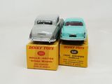 two toy cars sitting on top of boxes on a table