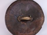 an old metal plate with a handle on it