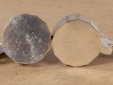 pair of silver and gold cufflinks on a brown surface