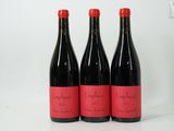 trois bouteilles de vin rouge posées côte à côte sur une table