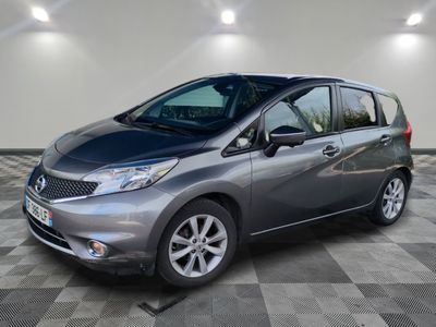 une Nissan Versa grise garée sur un sol à damier dans un garage