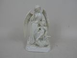 une statue blanche représentant un ange tenant un bébé dans ses bras