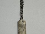 a close up of a metal dog tag on a chain