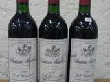 trois bouteilles de vin posées sur une table en bois