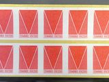 a close up of four red and white stickers on a table