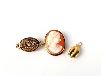 deux bijoux représentant le visage d'une femme et un œuf en or