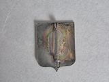 a small metal object on a white surface