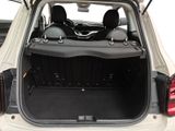 the back of a white car with its trunk open showing the seats