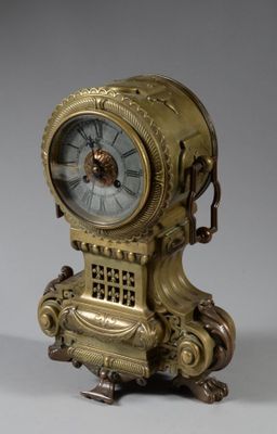a gold clock that is sitting on a stand