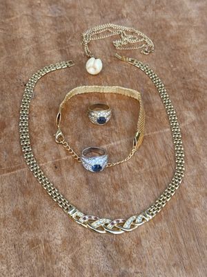 un gros plan d'un collier et d'un bracelet posés sur une surface en bois
