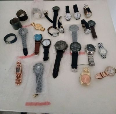 many different types of watches displayed on a table