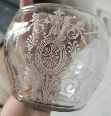une personne tenant un bocal en verre orné d'un motif