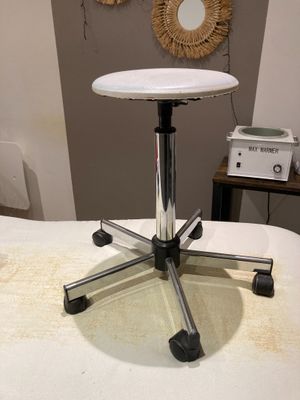 un tabouret blanc posé sur un lit blanc