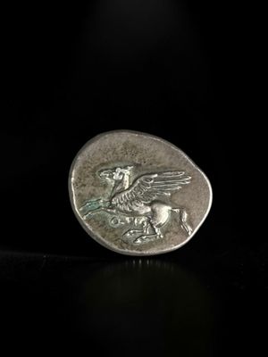 a close up of a silver coin with a bird on it