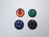 quatre cachets de cire de couleurs différentes sur une surface blanche