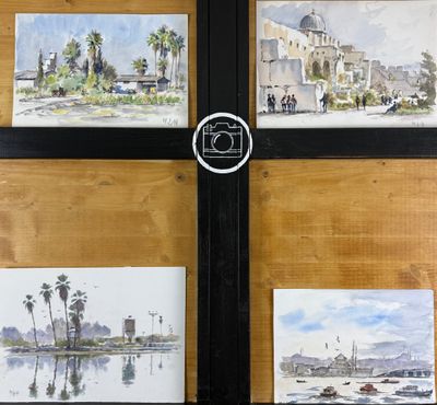 quatre tableaux accrochés au mur d'un immeuble sur lequel se trouve une horloge