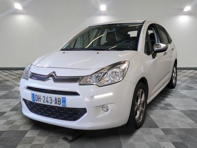 the small white car is parked on a checkered floor