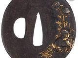 une tsuba noire ornée d'un décor doré