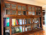 a large wooden cabinet with many books on it
