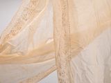 beige sheery fabric with white lace on it hanging from the ceiling
