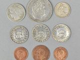 six different coins are shown in a row on a gray surface
