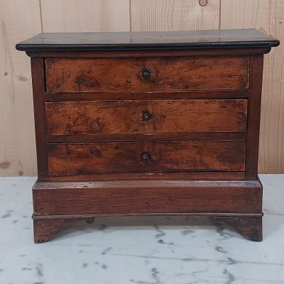 une petite commode en bois posée sur une table