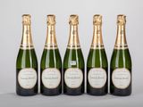 quatre bouteilles de champagne alignées sur une table