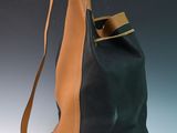 an image of a black and tan bag on a gray background