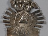 une image représentant un bijou en argent orné d'anges