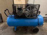 a blue air compressor sitting on top of a blue cart