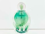 a glass jar with a green liquid inside of it