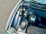 une voiture dont le capot est ouvert et le moteur se trouve dans le coffre