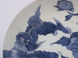 a blue and white plate with a picture of a woman and a bird on it