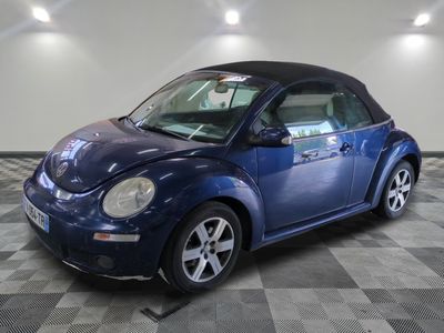 une photo d'une Volkswagen Coccinelle décapotable bleue garée sur un sol à damier